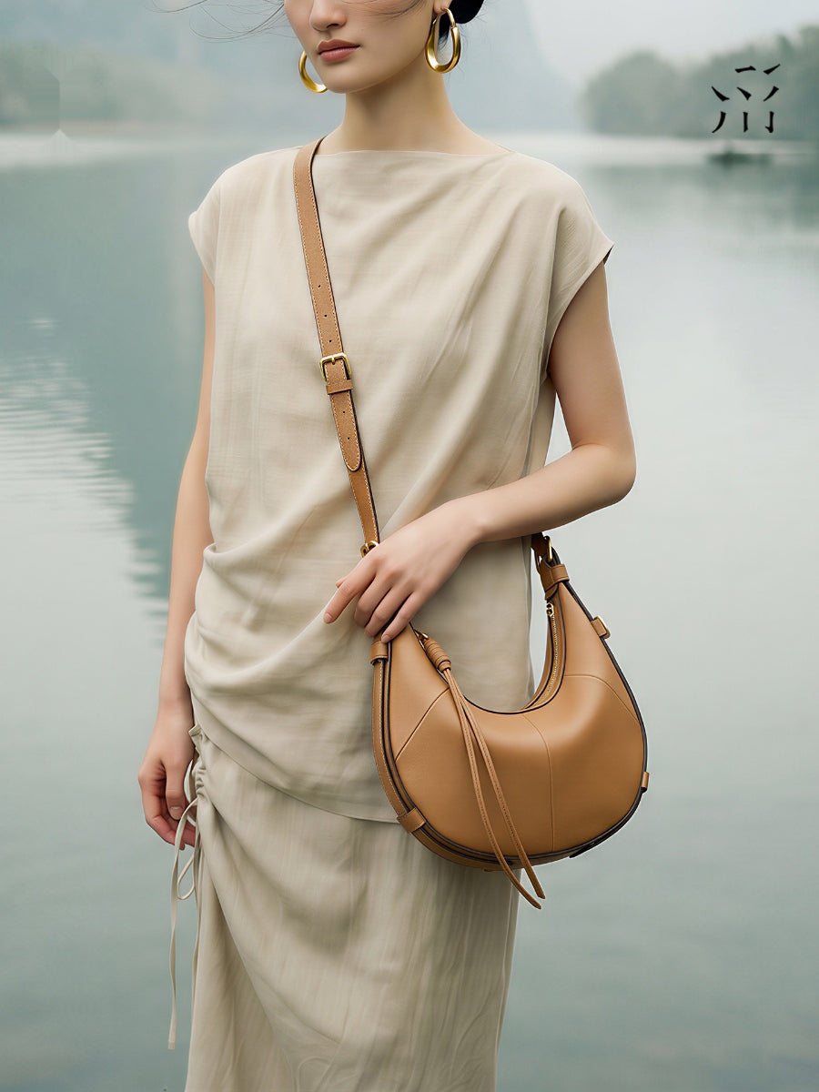 A Small, Sleek Hobo Bag In Vegetable-tanned Top-grain Cowhide, Perfect For Crossbody Or Commuting, Featuring A Summery Crescent Shape, Suitable For Women's Shoulder Or Underarm Wear.