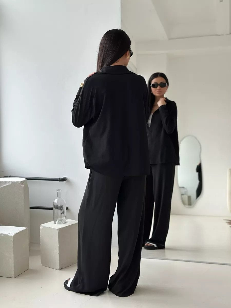 Zweiteiliges Set aus einfarbiger Strickjacke mit Taschen und lässiger, weit geschnittener Hose.