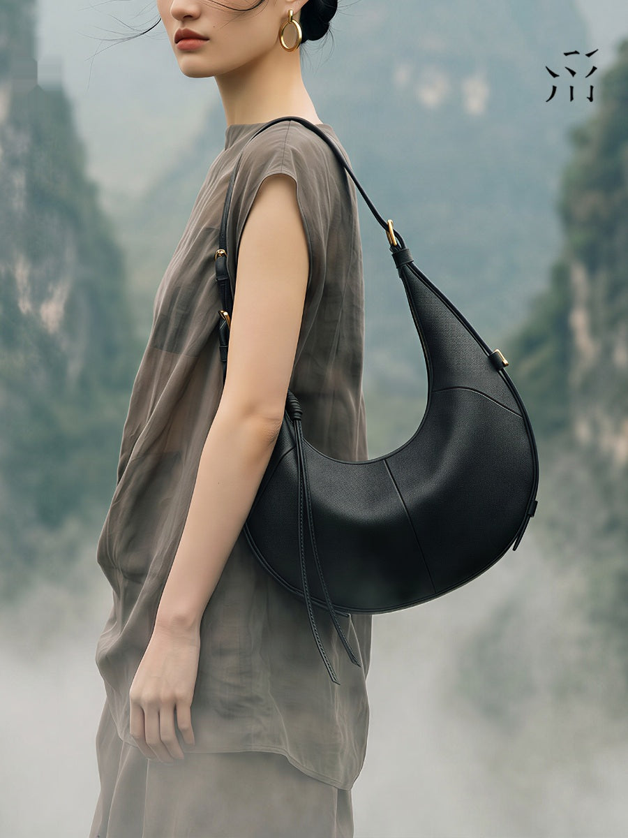 A Small, Sleek Hobo Bag In Vegetable-tanned Top-grain Cowhide, Perfect For Crossbody Or Commuting, Featuring A Summery Crescent Shape, Suitable For Women's Shoulder Or Underarm Wear.