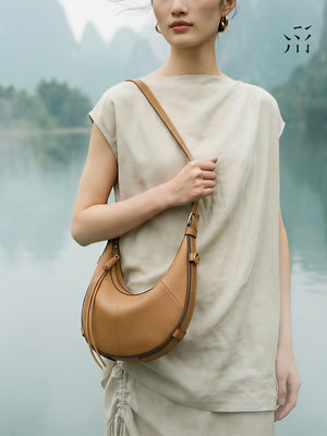 A Small, Sleek Hobo Bag In Vegetable-tanned Top-grain Cowhide, Perfect For Crossbody Or Commuting, Featuring A Summery Crescent Shape, Suitable For Women's Shoulder Or Underarm Wear.