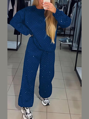 Zweiteiliges Set bestehend aus einem langärmeligen Top mit Rundhalsausschnitt, Strasssteinen und Kordelzug sowie einer Jogginghose.