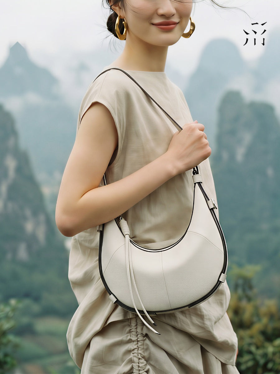 A Small, Sleek Hobo Bag In Vegetable-tanned Top-grain Cowhide, Perfect For Crossbody Or Commuting, Featuring A Summery Crescent Shape, Suitable For Women's Shoulder Or Underarm Wear.