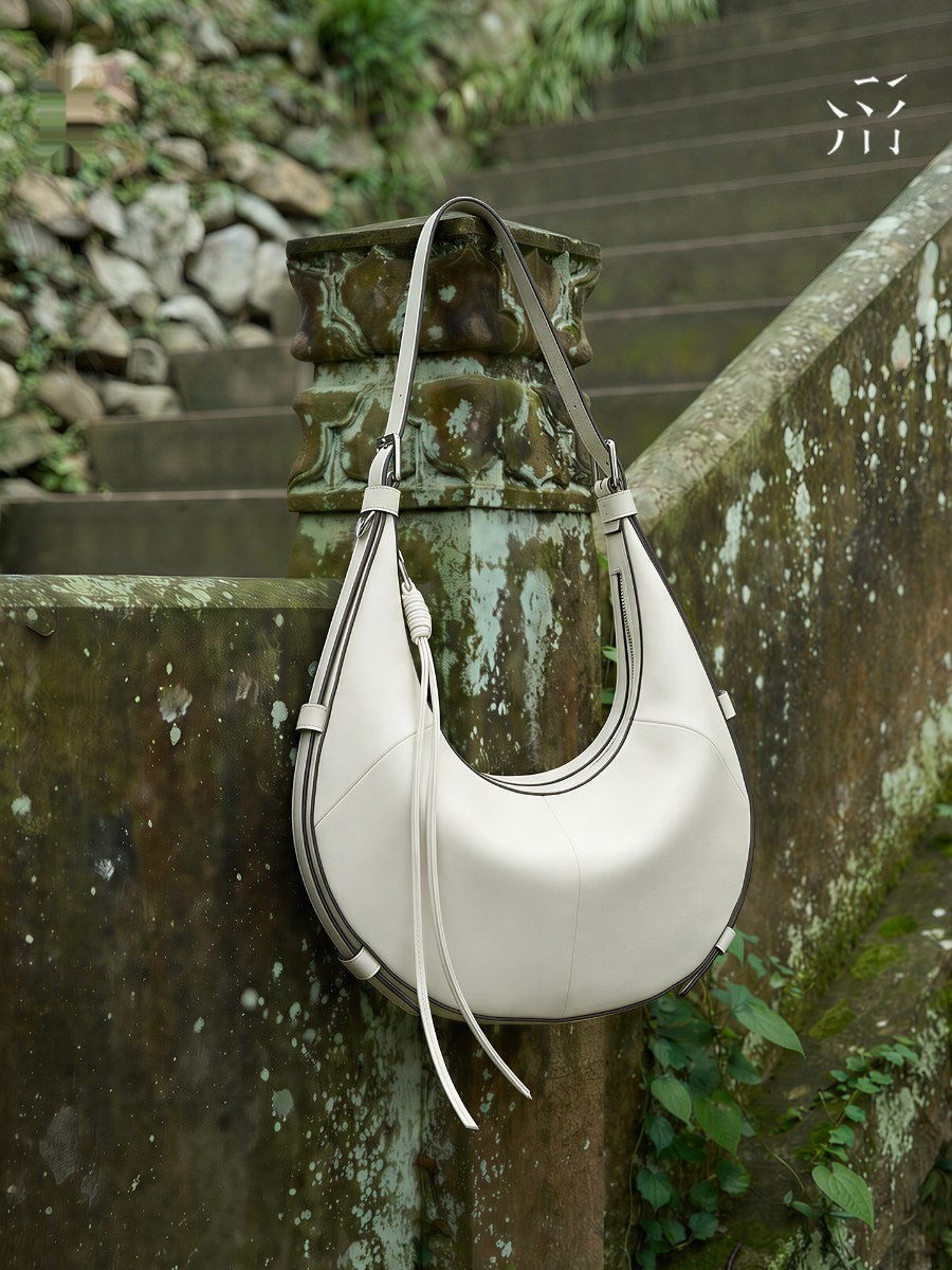 A Small, Sleek Hobo Bag In Vegetable-tanned Top-grain Cowhide, Perfect For Crossbody Or Commuting, Featuring A Summery Crescent Shape, Suitable For Women's Shoulder Or Underarm Wear.