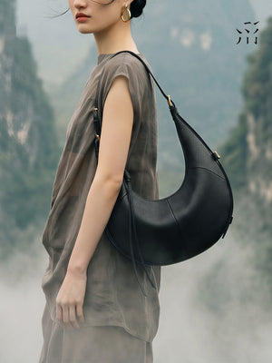 A Small, Sleek Hobo Bag In Vegetable-tanned Top-grain Cowhide, Perfect For Crossbody Or Commuting, Featuring A Summery Crescent Shape, Suitable For Women's Shoulder Or Underarm Wear.