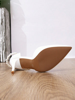 Escarpins blancs à talons hauts ornés de chaînes métalliques perlées