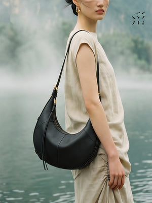A Small, Sleek Hobo Bag In Vegetable-tanned Top-grain Cowhide, Perfect For Crossbody Or Commuting, Featuring A Summery Crescent Shape, Suitable For Women's Shoulder Or Underarm Wear.